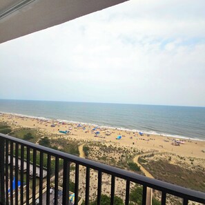 A beach view from a balcony with a railing, sandy beach, and ocean. - Enjoy beautiful oceanfront views of the Ocean City coastline in this one bedroom, one bath condo located just a few steps from the beach! (Ocean City)