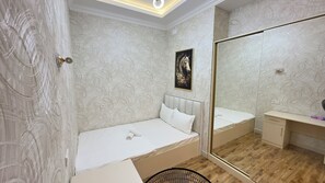 Ein Schlafzimmer mit einem Bett, einem Nachttisch, einem Spiegel und einem Wandbild.