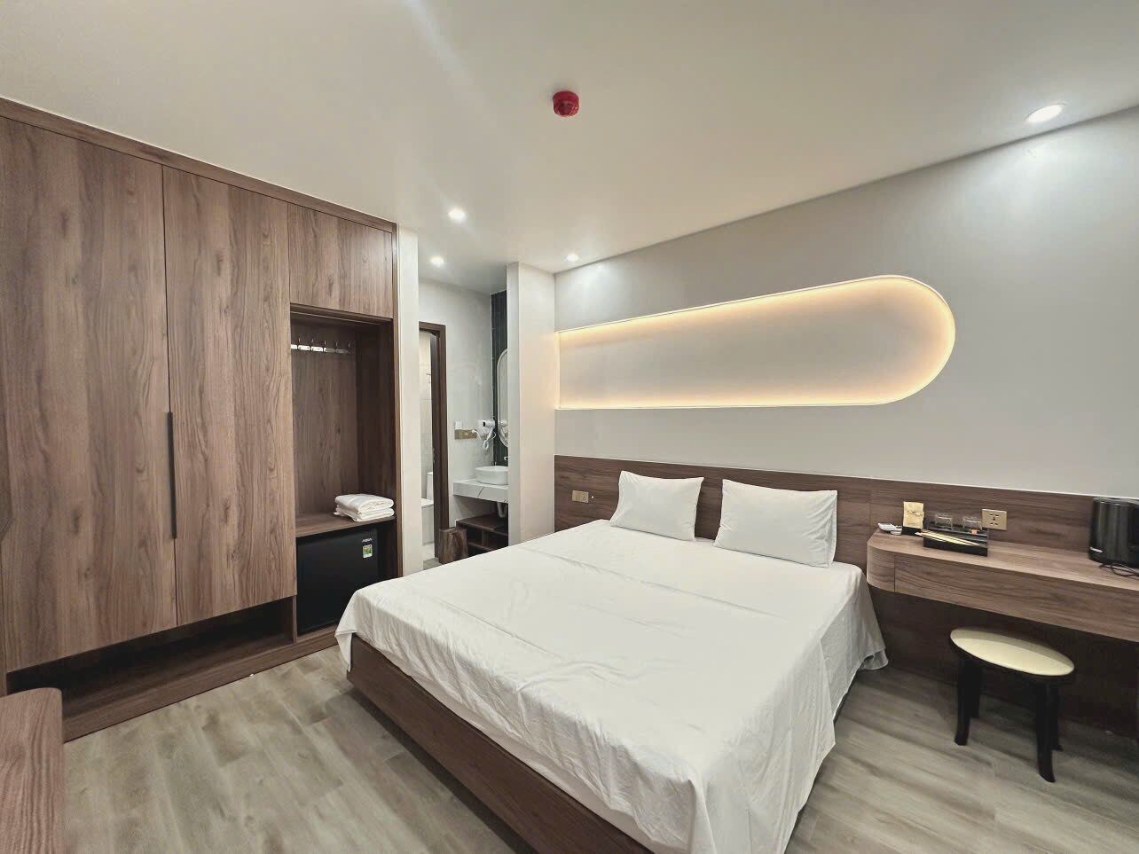 Une chambre d’hôtel moderne avec un grand lit, un bureau et une armoire.