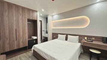 Une chambre d’hôtel moderne avec un grand lit, un bureau et une armoire.