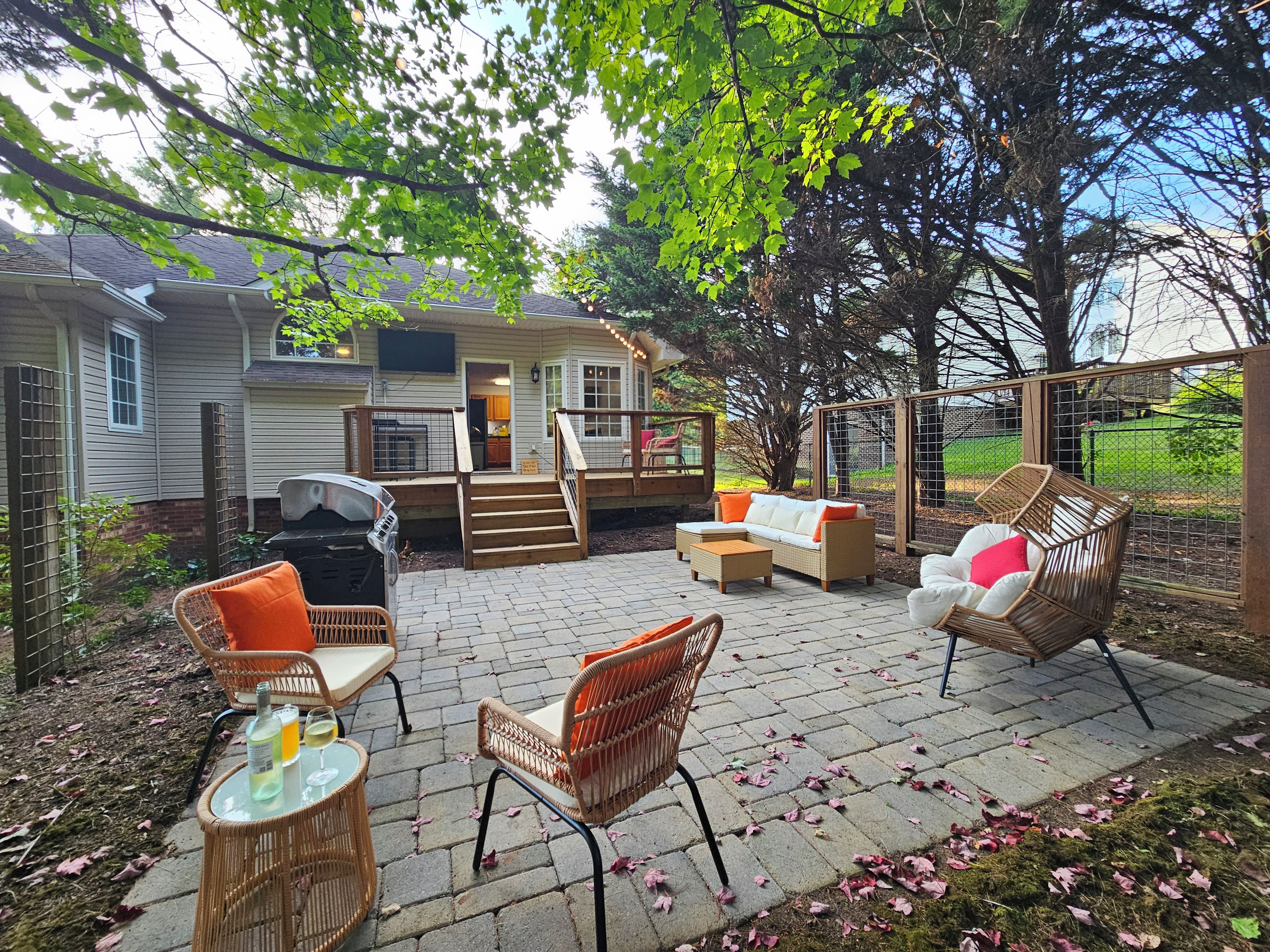 A patio area with outdoor furniture, a covered seating area, and a house in the background.