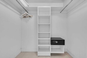 Ein weißer Schrank mit mehreren Regalen und einer schwarzen Aufbewahrungsbox.