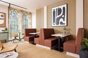 Ein modernes Interieur mit Sitzgelegenheiten, einem Tisch und einem großen, abstrakten Gemälde.
