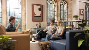 A modern living room with a sofa, a coffee table, and potted plants. - Student Only Cathedral Park (Bristol)