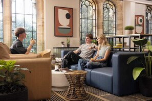 Ein modernes Wohnzimmer mit einer Couch, einem Couchtisch und Topfpflanzen.