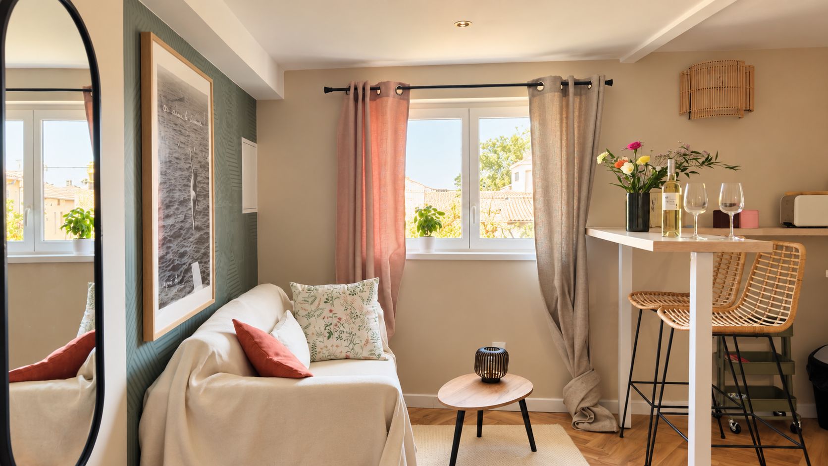 A cozy room with a bed, a small table with chairs, a window with curtains, and a wall-mounted shelf with decorative items.