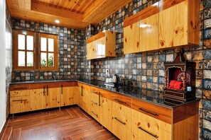 Una cocina con armarios de madera, salpicadero de azulejos y una ventana.