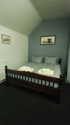 A bedroom with a single bed, two pillows, and a framed picture on the wall. - Sharvels Oast House - Pool, Tennis, Luxury Home (Rye)