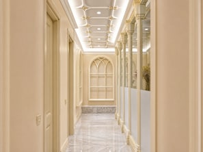 A corridor with a marble floor, a large arched window, and a mirrored wall. - Midway Park Hotel (Baku)