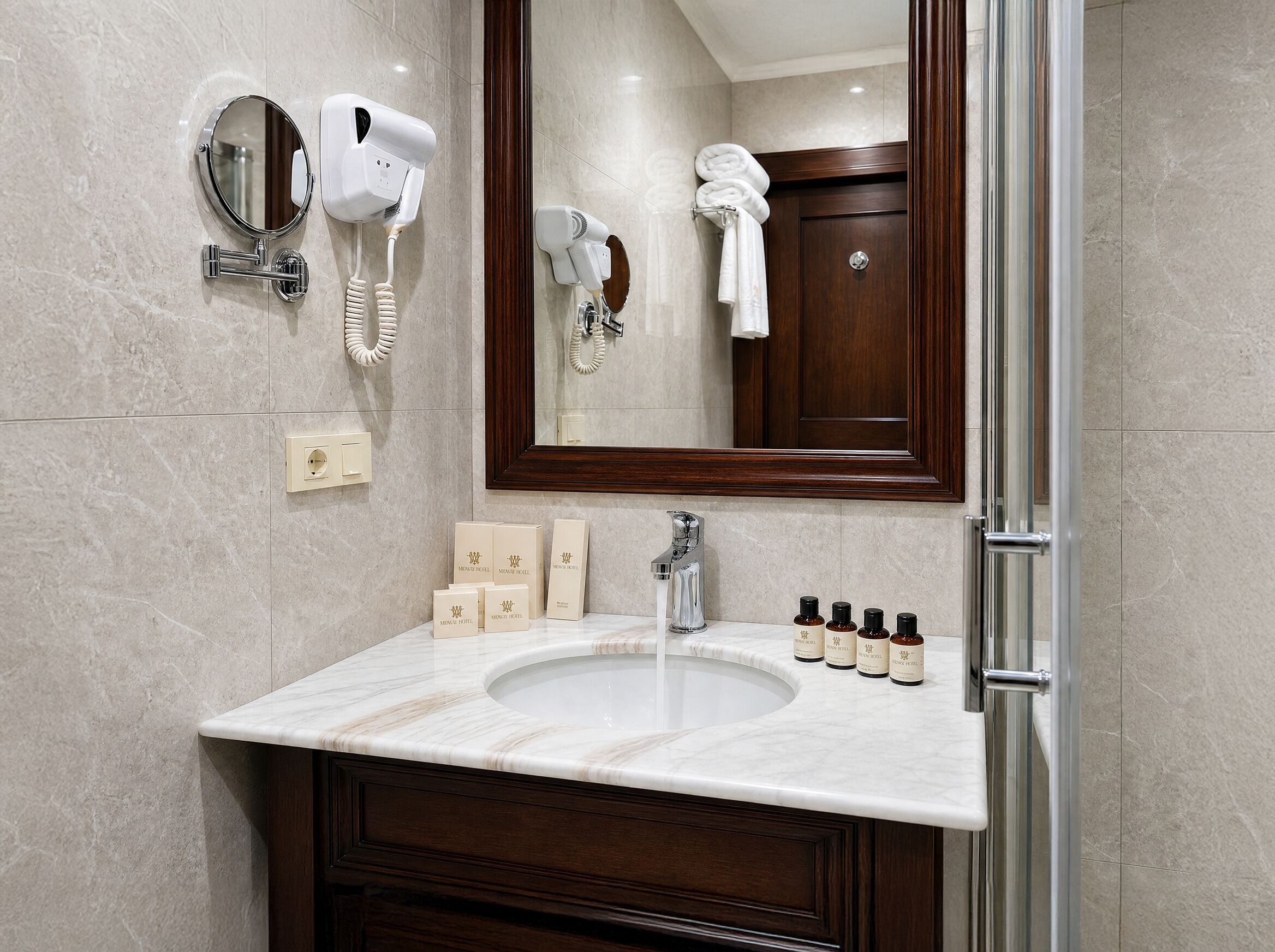 A bathroom with a marble sink, a mirror, a hairdryer, and toiletries.
