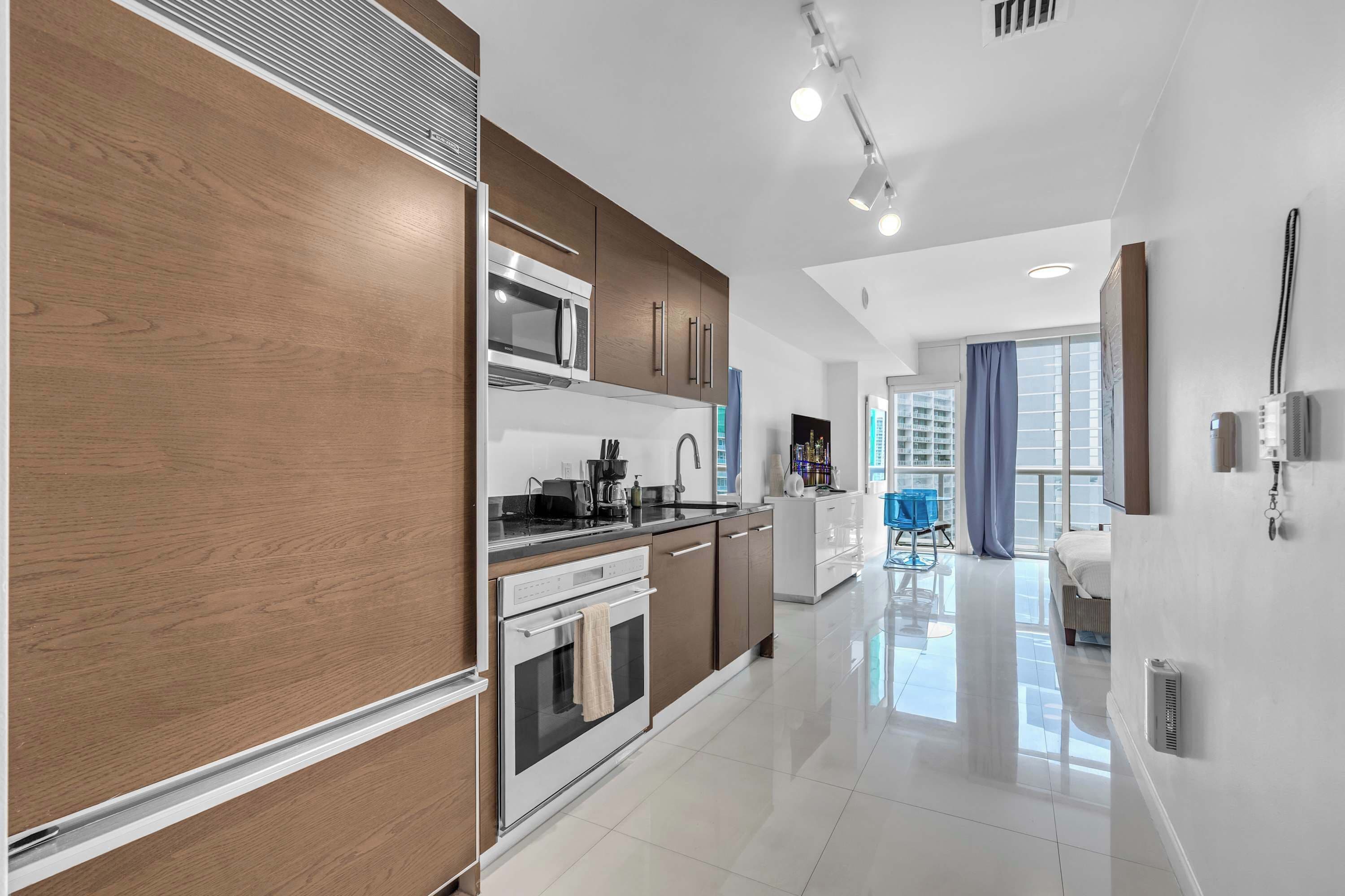 A modern kitchen with a built-in oven, microwave, and a coffee maker.