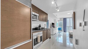A modern kitchen with a built-in oven, microwave, and a coffee maker. - Luxe Condo on Miami River (Miami)