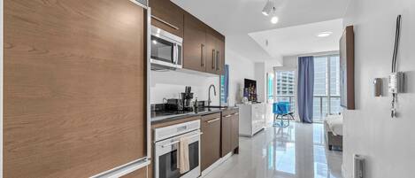 A modern kitchen with a built-in oven, microwave, and a coffee maker.