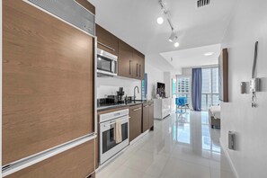 A modern kitchen with a built-in oven, microwave, and a coffee maker. - Luxe Condo on Miami River (Miami)