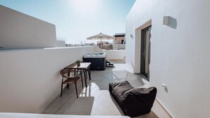 A rooftop terrace with a dining area, a hot tub, and a sofa. - Nonna's Suites (Naxos)