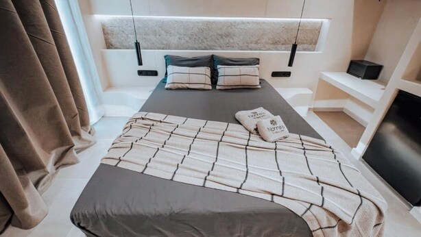 A bed with a headboard, pillows, and a blanket. - Nonna's Suites (Naxos)