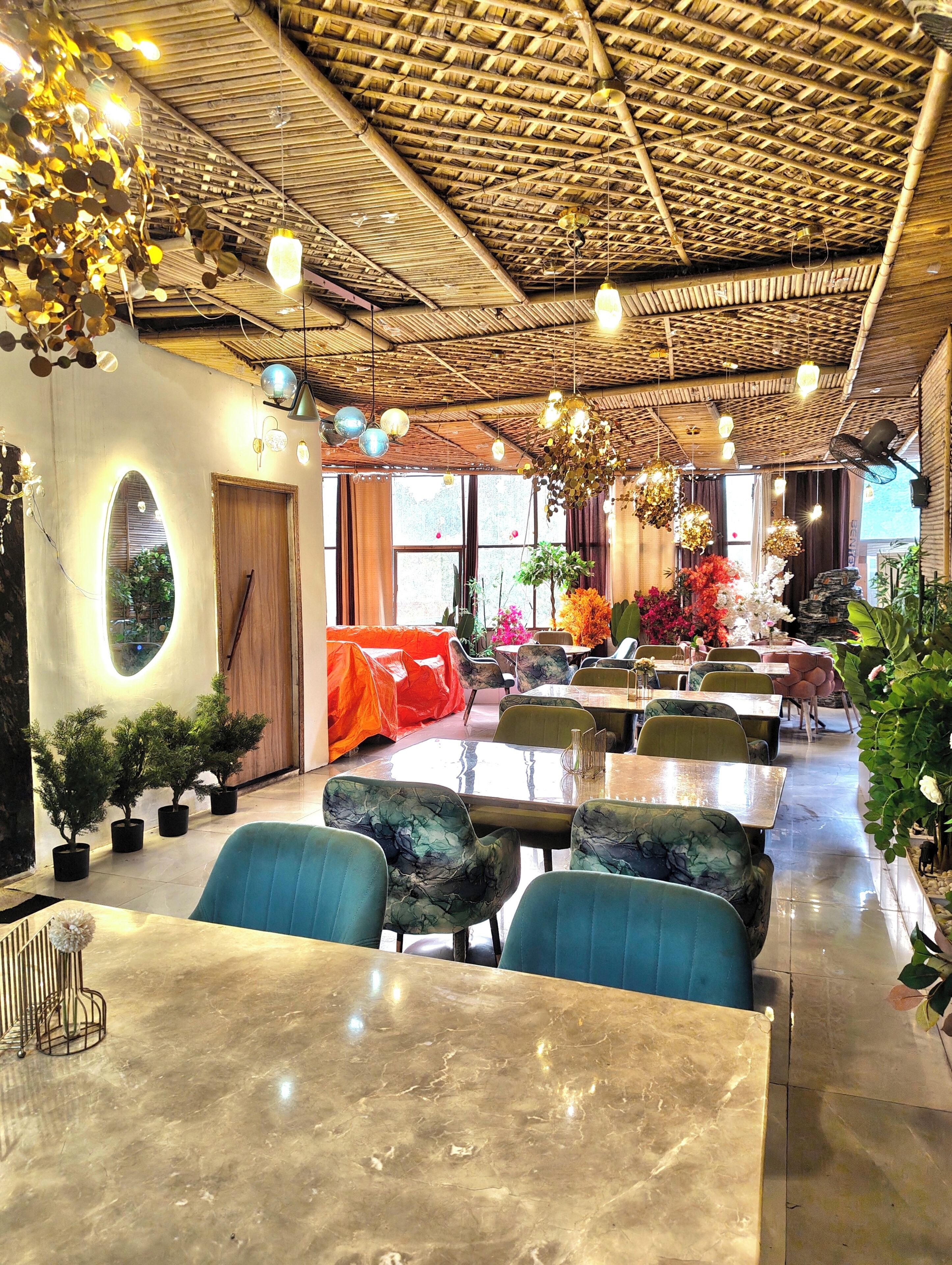 A restaurant interior with a bamboo ceiling, round tables, and blue chairs.