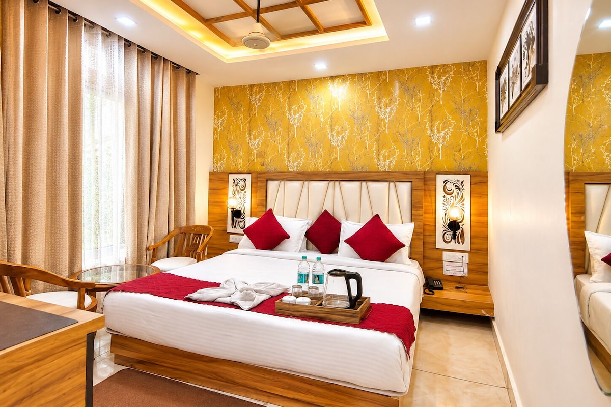 A hotel room with a bed, a desk, and a chair.