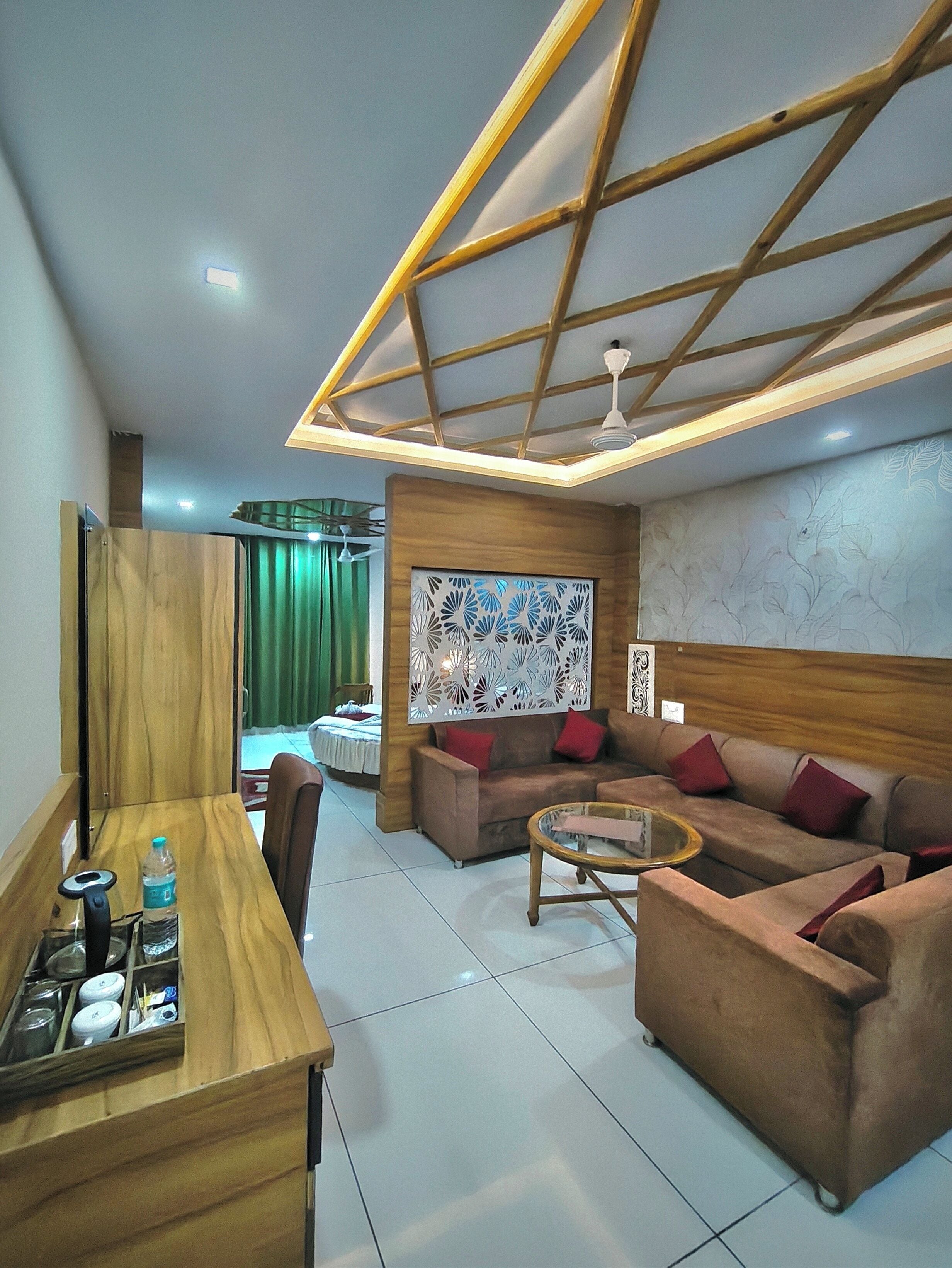A modern living room with a wooden dining table, a sofa set, and a decorative ceiling.