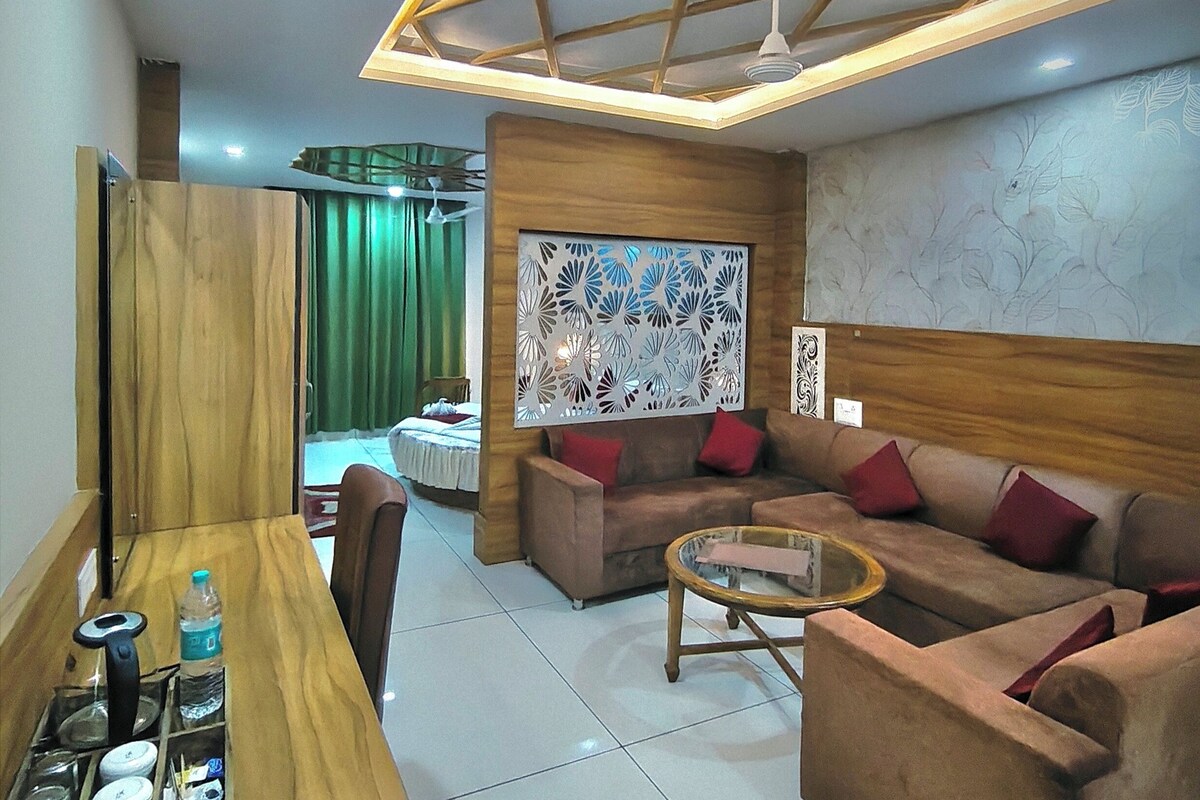 A modern living room with a wooden dining table, a sofa set, and a decorative ceiling.