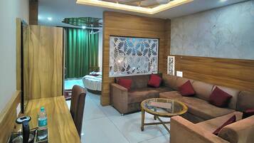 A modern living room with a wooden dining table, a sofa set, and a decorative ceiling.