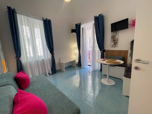 Uma sala de estar moderna com um sofá, uma mesa de jantar e uma cozinha.