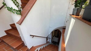 A staircase with terracotta tiles and a white wall, leading to an upper level. - Sweet Home Luna: a charming apartment in the heart of Amalfi (Amalfi)