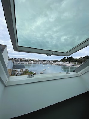 A view from a window overlooking a harbor with boats and buildings.