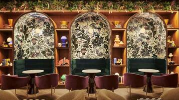 A room with three arched display cases, a round table, and purple chairs.