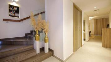 Un intérieur moderne avec un escalier, une porte en bois et un tableau encadré au mur.