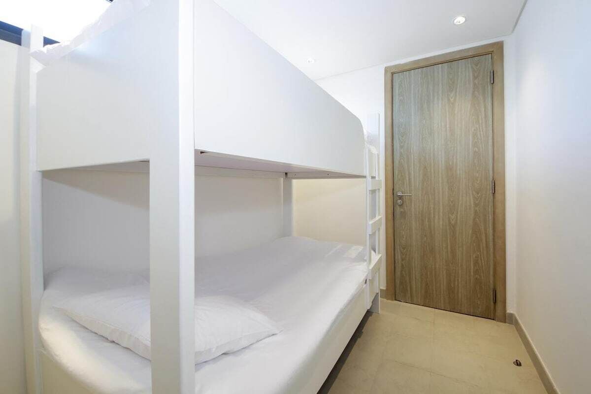 A bunk bed room with a wooden door and a small hallway.