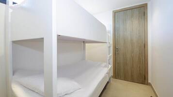 A bunk bed room with a wooden door and a small hallway.
