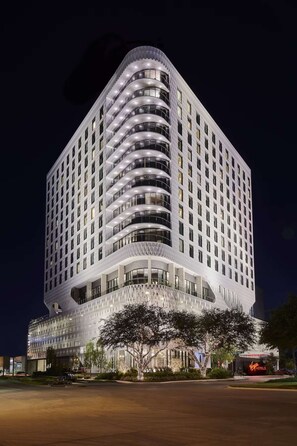 A modern hotel with a curved facade, multiple balconies, and a prominent Virgin Hotels sign. - Close to American Airlines Center + Dining & Pool (Dallas)