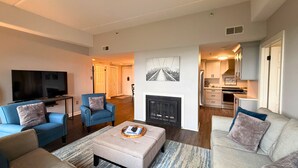 A modern living room with a television, sofas, and a fireplace. - 6th floor condo- hot tub- views of Grandfather Mountain (Sugar Mountain)