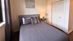 A bedroom with a bed, a nightstand, a lamp, a closet, and a painting on the wall. - 6th floor condo- hot tub- views of Grandfather Mountain (Sugar Mountain)