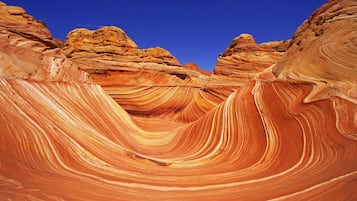 A canyon with layered rock formations and a clear blue sky.