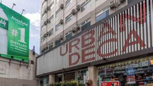 A building with a large sign that reads 'URBAN BECA' and a green sign advertising 'Absolute #1 Distilled Water for the Philippines'. - City Comfort at Urban Deca Towers Cubao (Quezon City)
