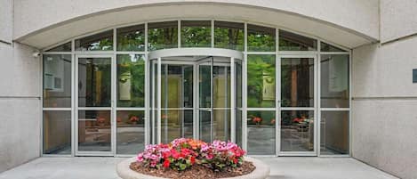 Grand entrance with revolving doors and seasonal flower display