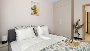 Ein Schlafzimmer mit Bett, Nachttisch, Kleiderschrank und einer Tür.