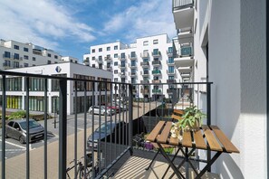 A balcony with a view of a parking lot and a building with multiple balconies. - Cosy Apartment with a Balcony | Parking | Close to Green Spaces (Poznań)