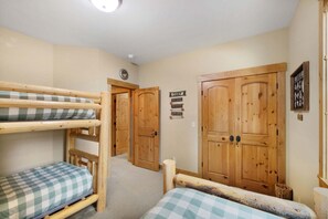 Et værelse med køjesenge, et træskab og et skilt der viser faciliteter som camping, sauna og levende lokkemad.