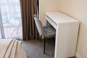 A room with a bed, a desk, a chair, and a window with curtains. - Kivuli | Walk to Elizabeth Quay • Pool • Parking (Perth)