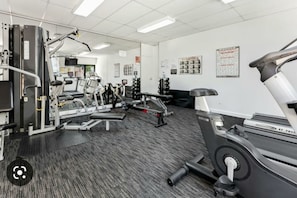 A gym with various exercise equipment, including a treadmill, weight machines, and a bench. - Kivuli | Walk to Elizabeth Quay • Pool • Parking (Perth)