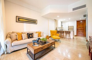 Ein modernes Wohnzimmer mit einer Couch, einem Couchtisch und einem Essbereich mit Stühlen.