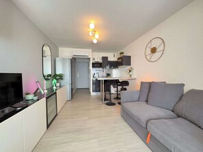 A modern apartment with a living room, kitchenette, and a dining area. - Cozy Seafront Studio on the Mediterranean (Agde)