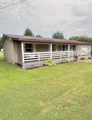 A single-story building with a porch and a fenced yard.
