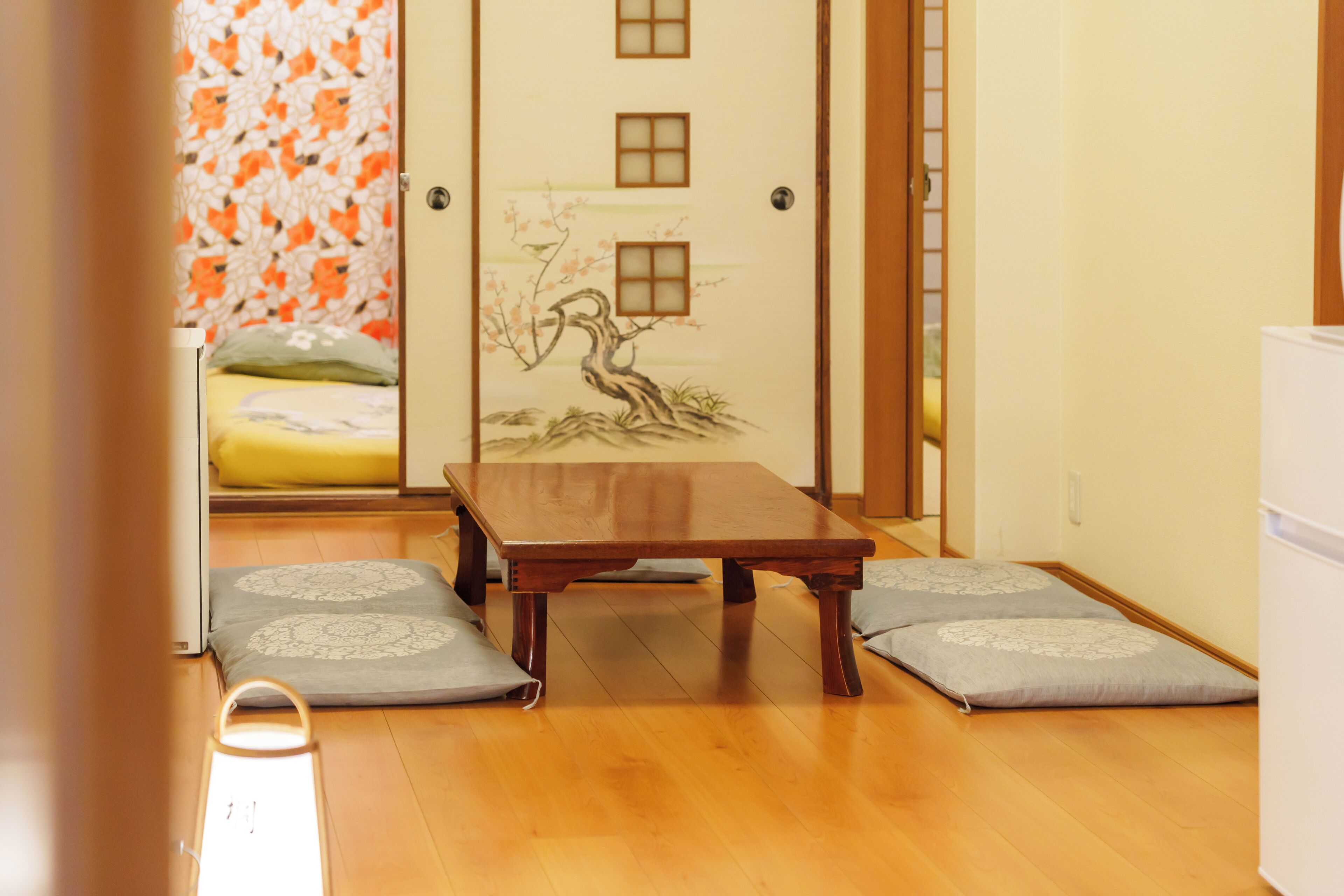 A traditional Japanese room with tatami flooring, a low wooden table, and shoji screens.