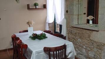 A dining area with a table set for four, surrounded by wooden chairs.