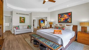 A hotel room with a bed, a sofa, a desk, a ceiling fan, and artwork on the walls. - Kapalua Ridge | 2 Ocean View Villas, Sleeps 12 | Car Incl. w/ 6+ Nights | ML-4253 by KBM (Lahaina)