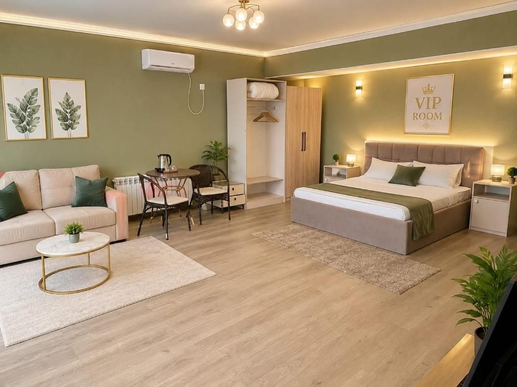 Habitació d'hotel amb llit, taules de nit, sofà, escriptori i cadira.